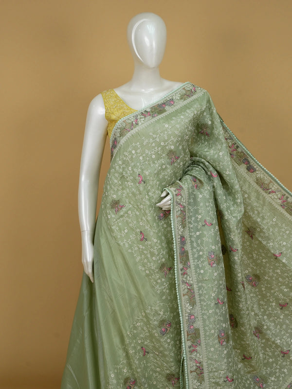 Sage green designer saree with white floral embroidery, pink bird and elephant motifs and pom-pom lace border