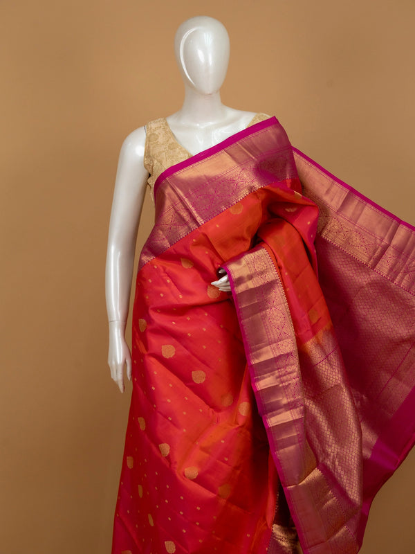 Orange pure Kanchipuram silk saree with contrast pink zari border and gold buttas