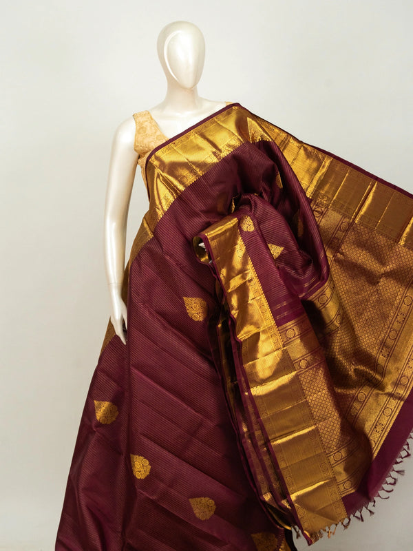 Maroon pure Kanchipuram silk saree with gold zari border, buttas and ornate woven pallu