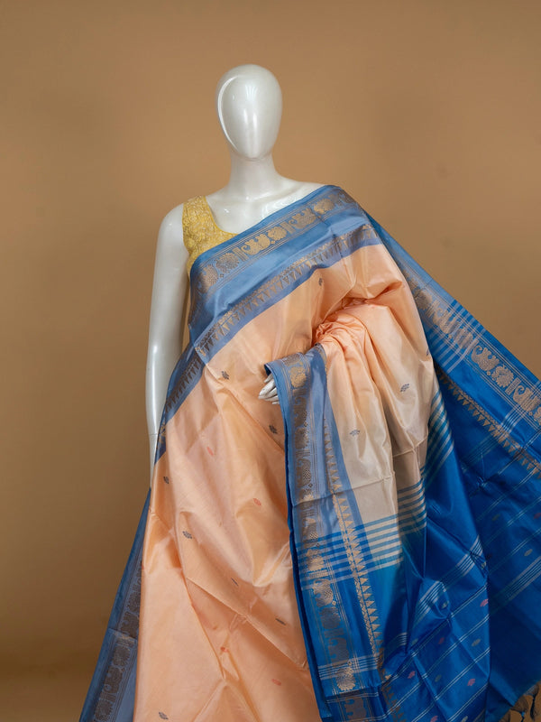 Peach banana silk saree with contrast blue zari border and elephant-peacock pallu motifs
