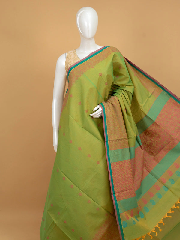 Parrot green silk cotton saree with coral pink contrast border, gold zari motifs, and woven paisley pallu