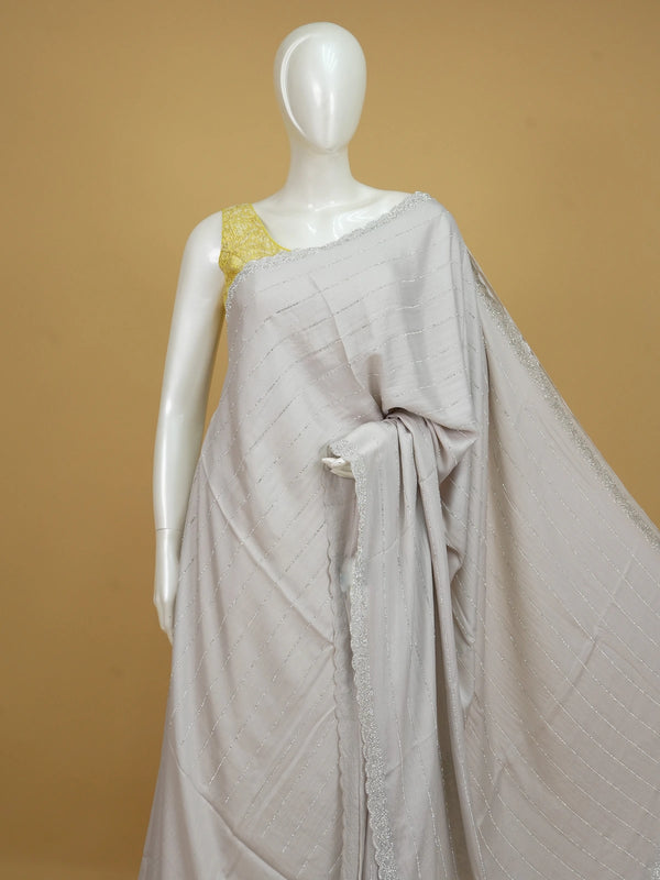 Light grey sheer designer saree with silver stone stripes and scalloped border, styled with a yellow embroidered blouse