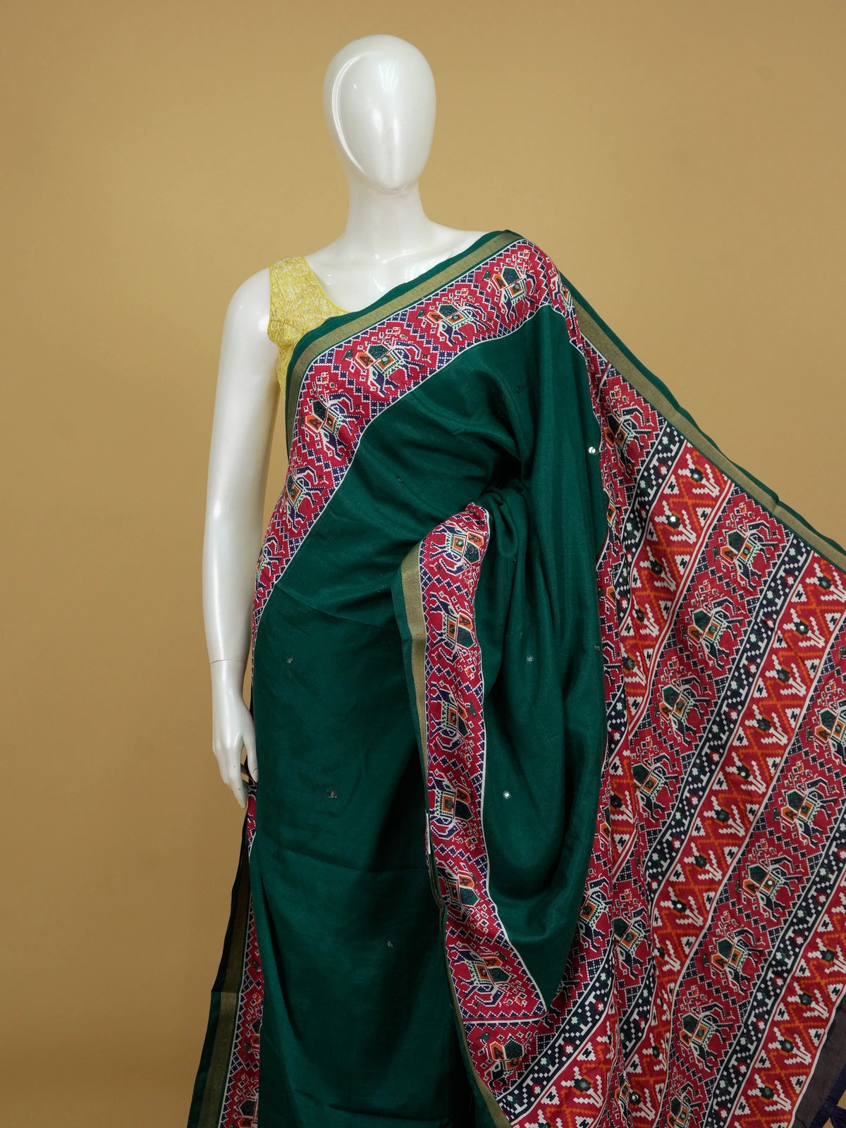 Deep green linen cotton saree with red patola-style elephant border and detailed pallu