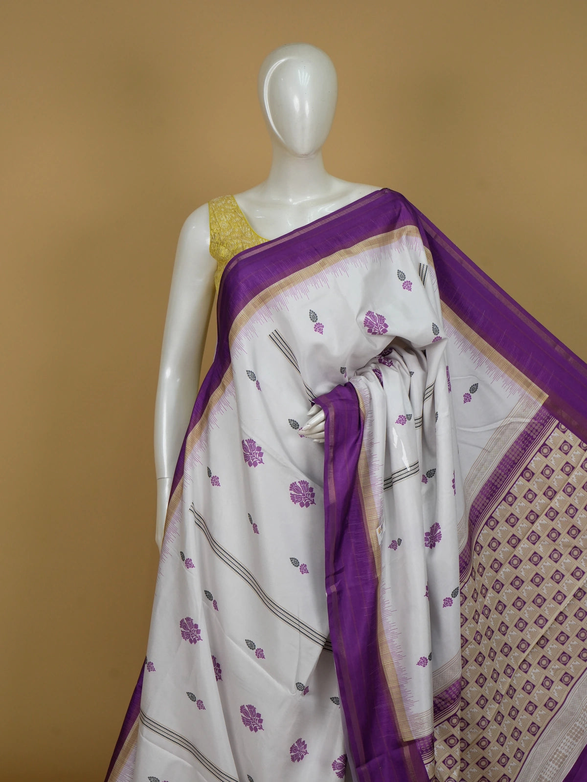 Cream Dola silk saree with purple floral buttas, gold zari contrast border and patterned purple pallu