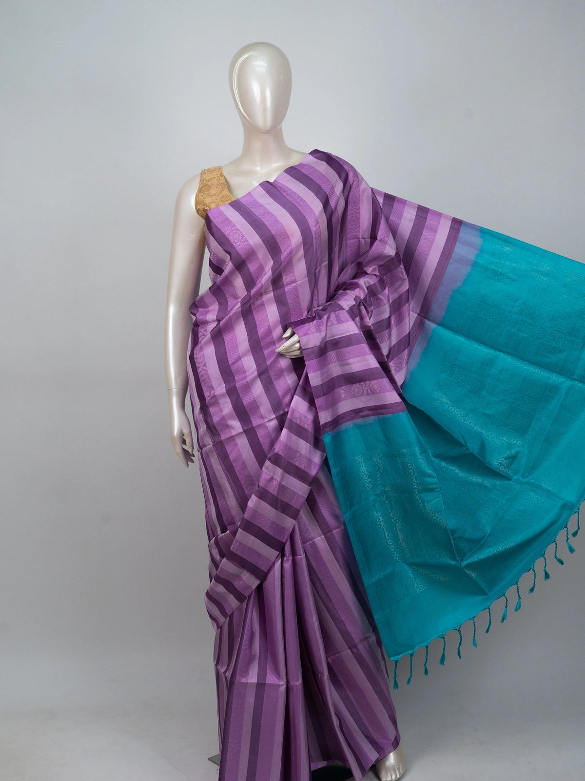 Purple striped soft silk saree with contrast teal pallu, gold zari buttis and tasselled edge