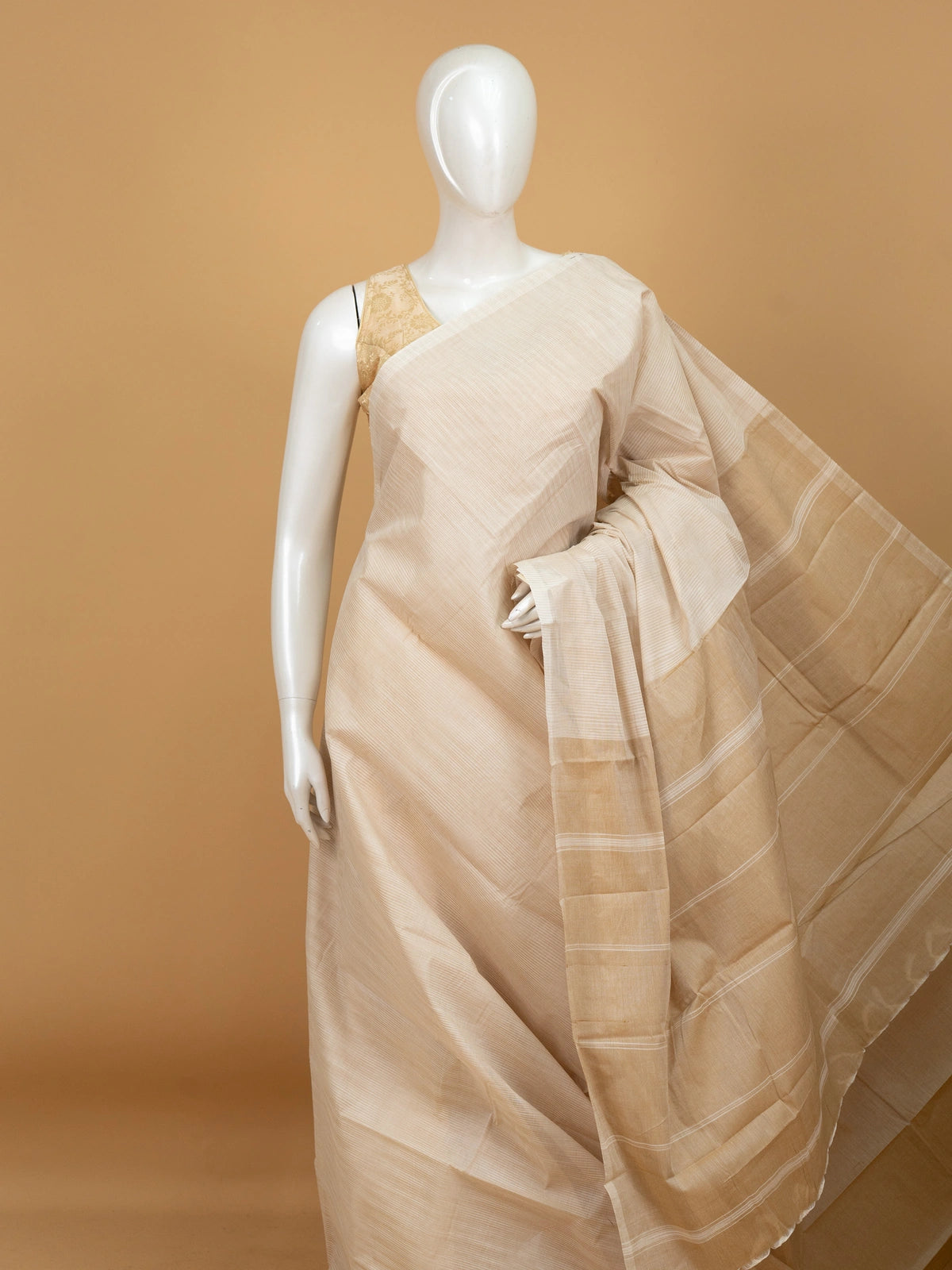 Cream and gold silk cotton saree with striped body, golden zari border and striped pallu