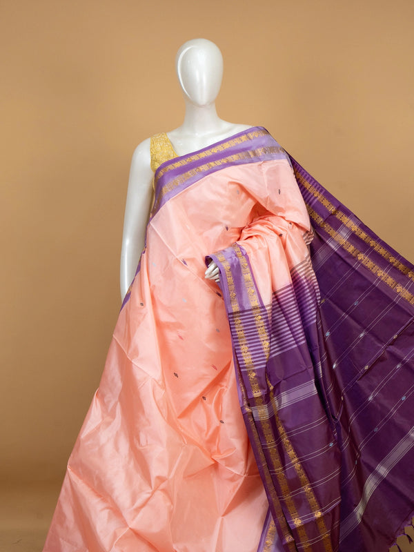 Peach banana silk saree with purple contrast border and gold zari pallu