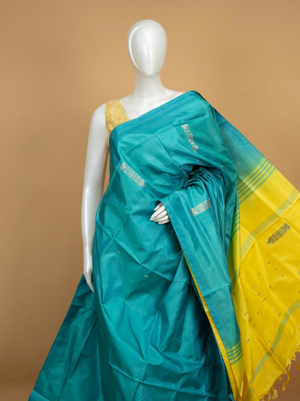 Teal banana silk saree with yellow contrast pallu, silver zari buttas, and matching yellow blouse