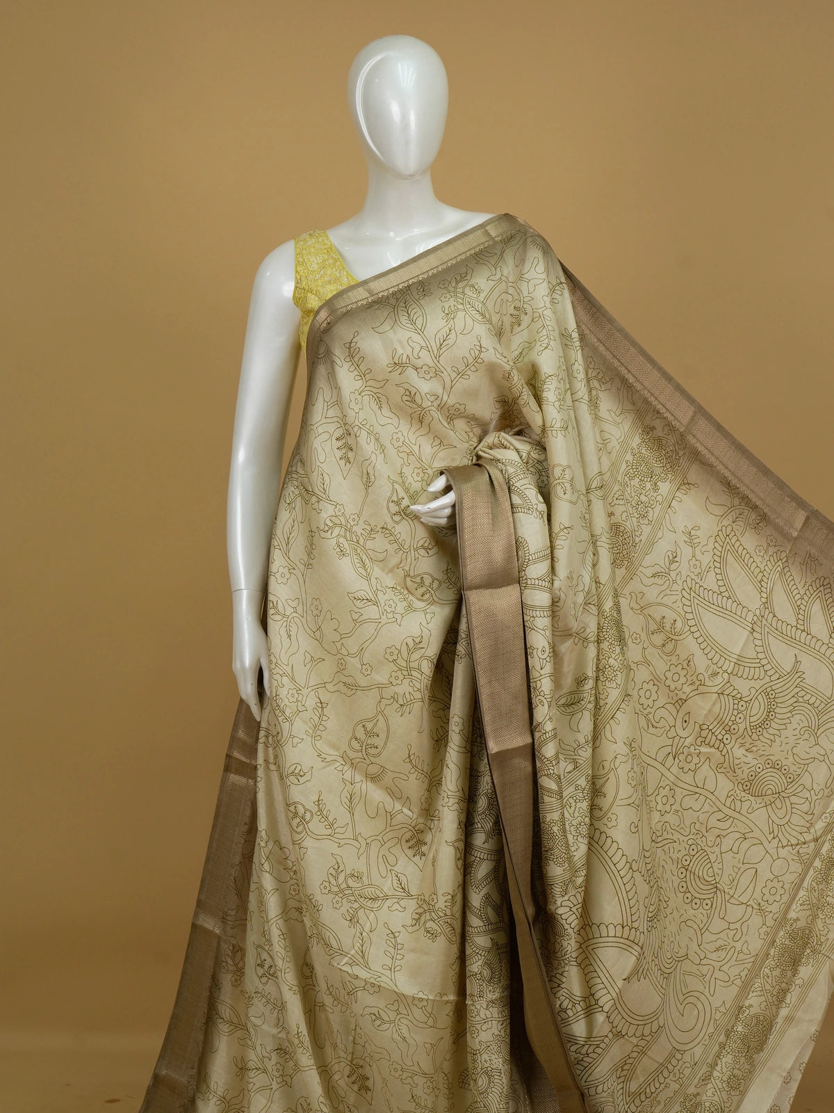Cream Dola silk saree with Kalamkari-style floral print, peacock pallu and gold zari border