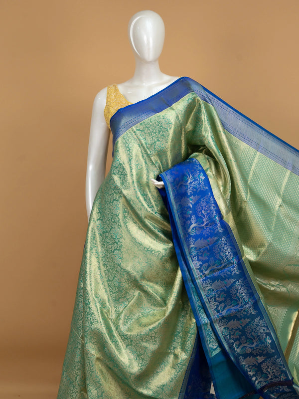 Green pure Kanchipuram silk saree with gold zari brocade and contrast royal blue peacock-motif border