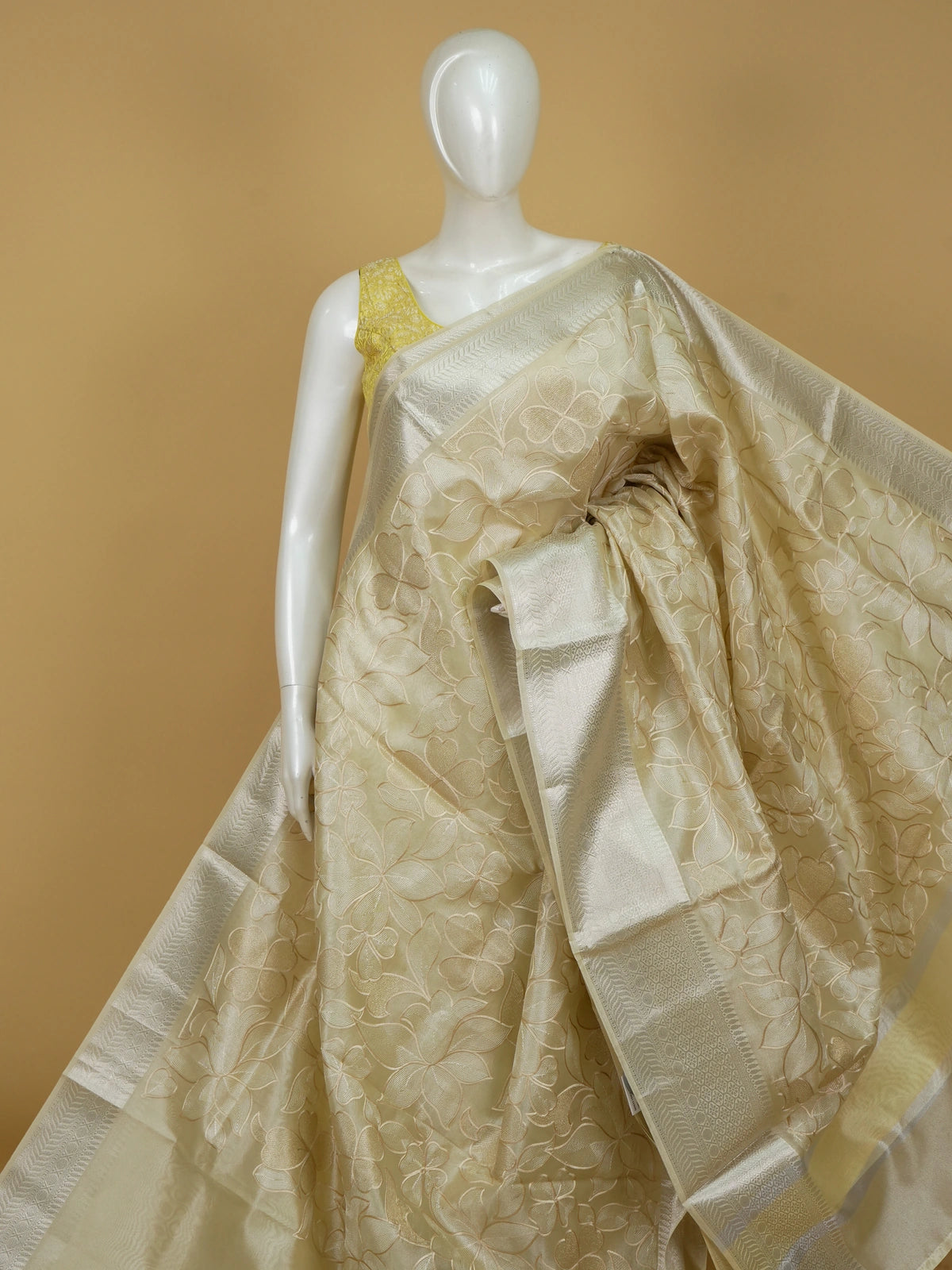 Cream tissue designer saree with floral embroidery and silver zari border