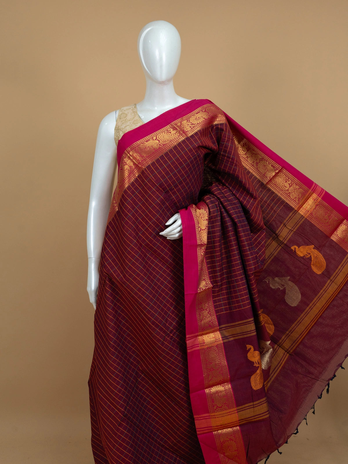 Maroon Chettinad cotton saree with checked body, contrast pink zari border and gold peacock motif pallu