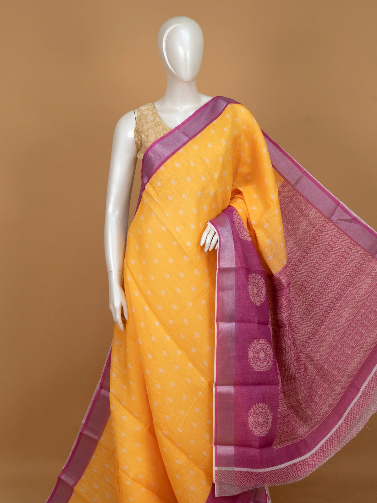 Yellow linen cotton saree with white diamond buttas and contrast pink border and pallu
