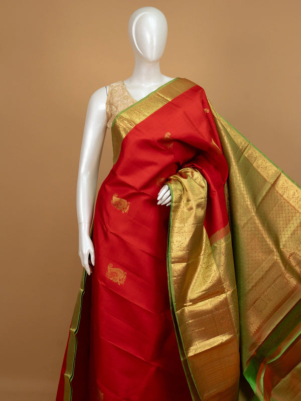 Red pure Kanchipuram silk saree with contrast green and gold zari border and paisley motifs