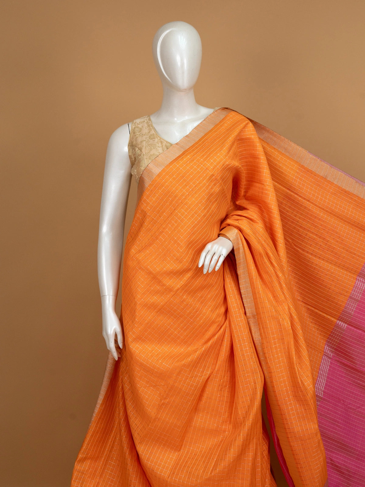 Orange linen cotton saree with white checks, contrast pink border with gold zari, and striped pink blouse