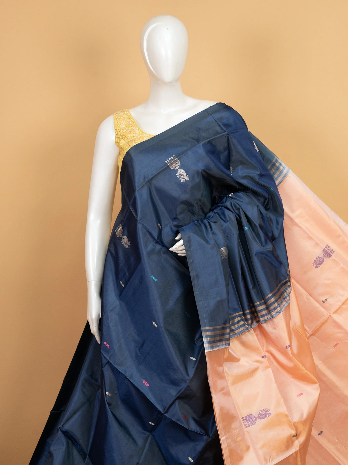 Navy blue banana silk saree with contrast peach pallu, peacock motifs and gold zari border