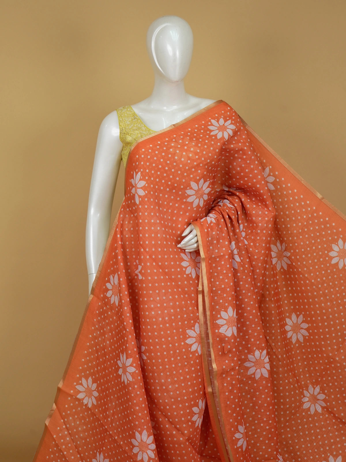 Orange linen cotton saree with white polka dots, floral motifs and a thin gold border