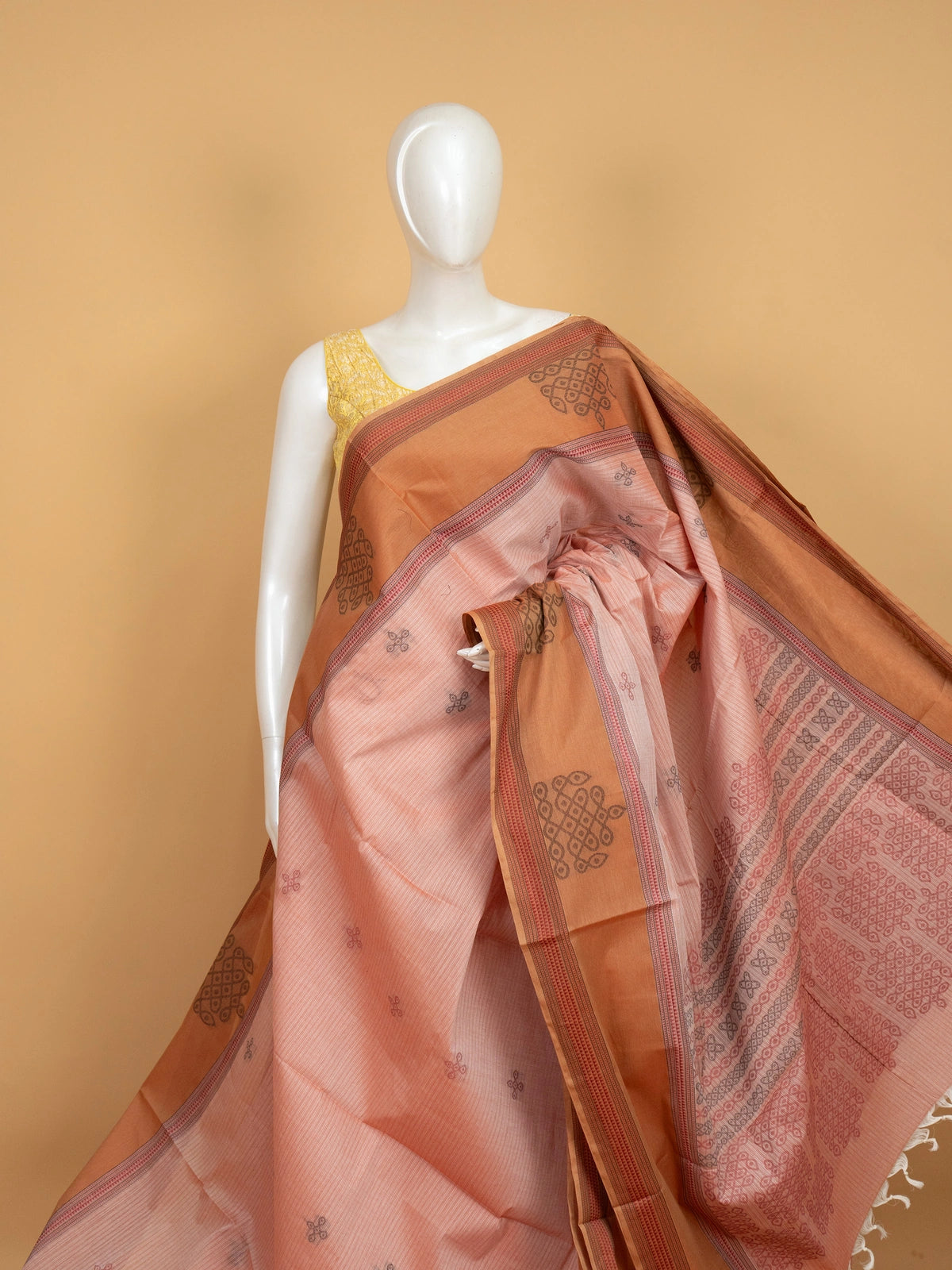 Pale pink and rust semi raw silk saree with kolam motifs and contrast patterned border