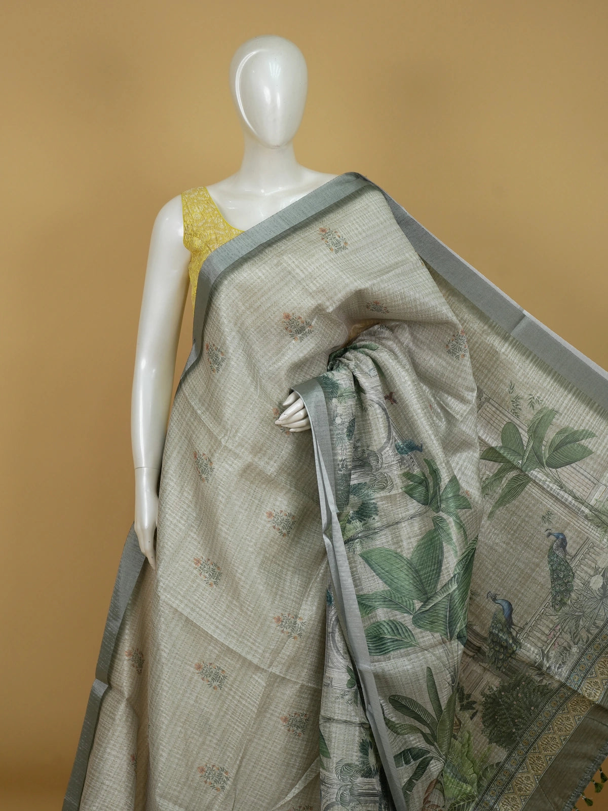 Grey and green semi tussar saree with floral buttas, silver-grey zari border and peacock scenic pallu