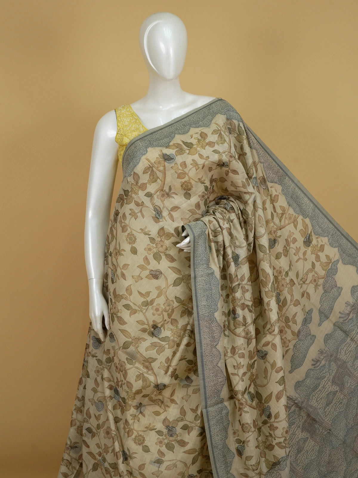Beige linen cotton saree with kalamkari floral-bird print, grey-green contrast border and deer-motif pallu