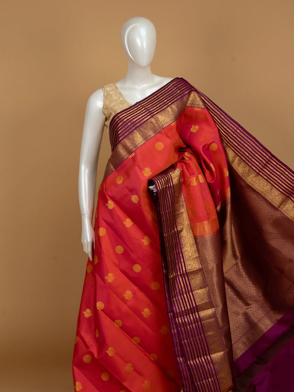 Orange-red pure Kanchipuram silk saree with gold zari buttas and contrast purple zari border and pallu
