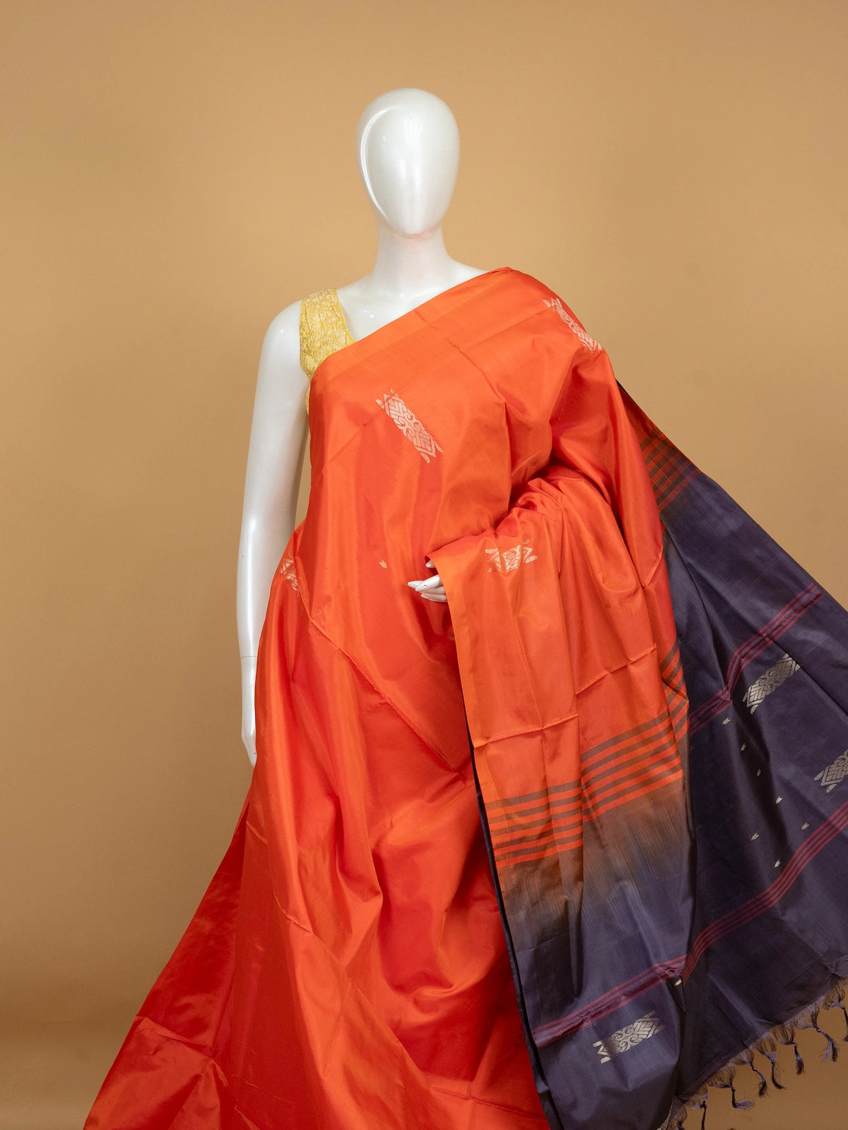 Orange banana silk saree with navy blue pallu, silver zari buttas and contrast blouse