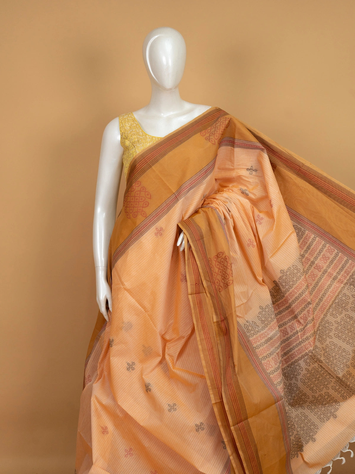 Peach and mustard semi raw silk saree with contrast border and kolam motif pallu