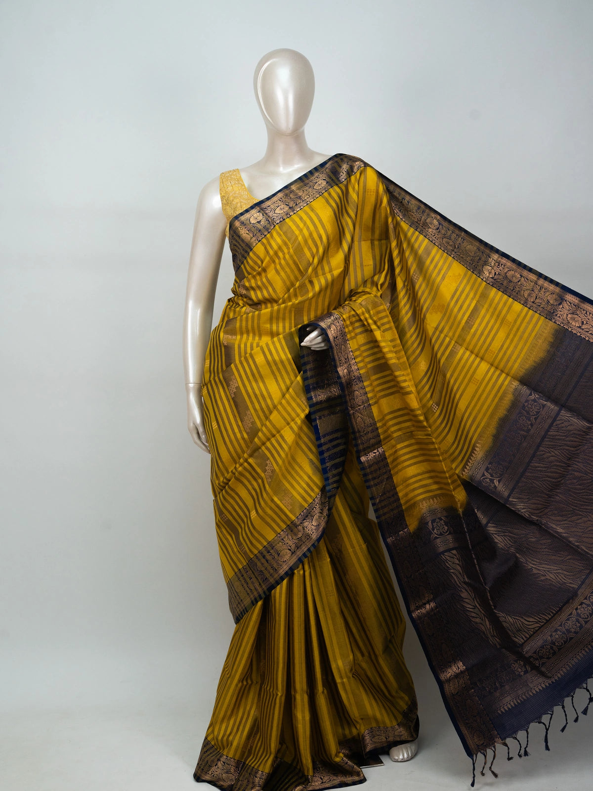 Mustard yellow soft silk saree with navy blue gold zari border and floral pallu