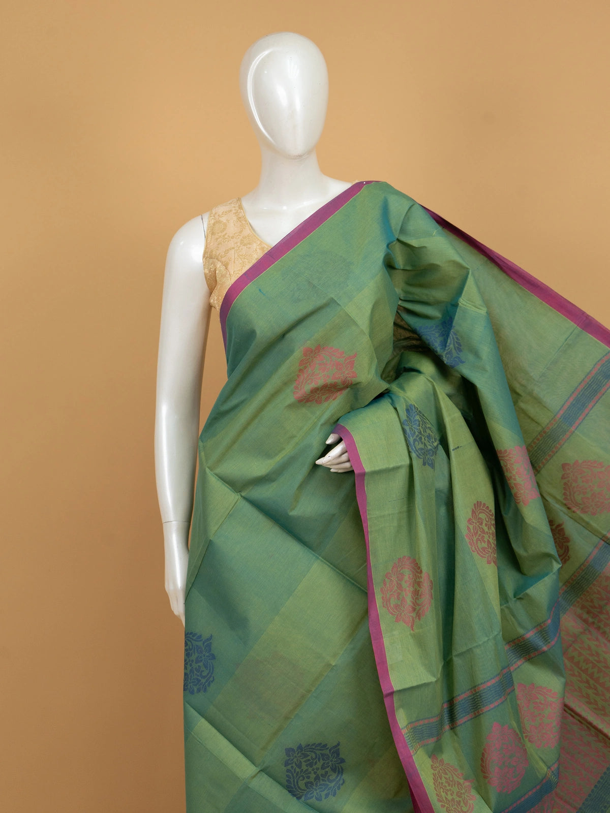 Green silk cotton saree with contrast pink border and pink and blue floral butta motifs