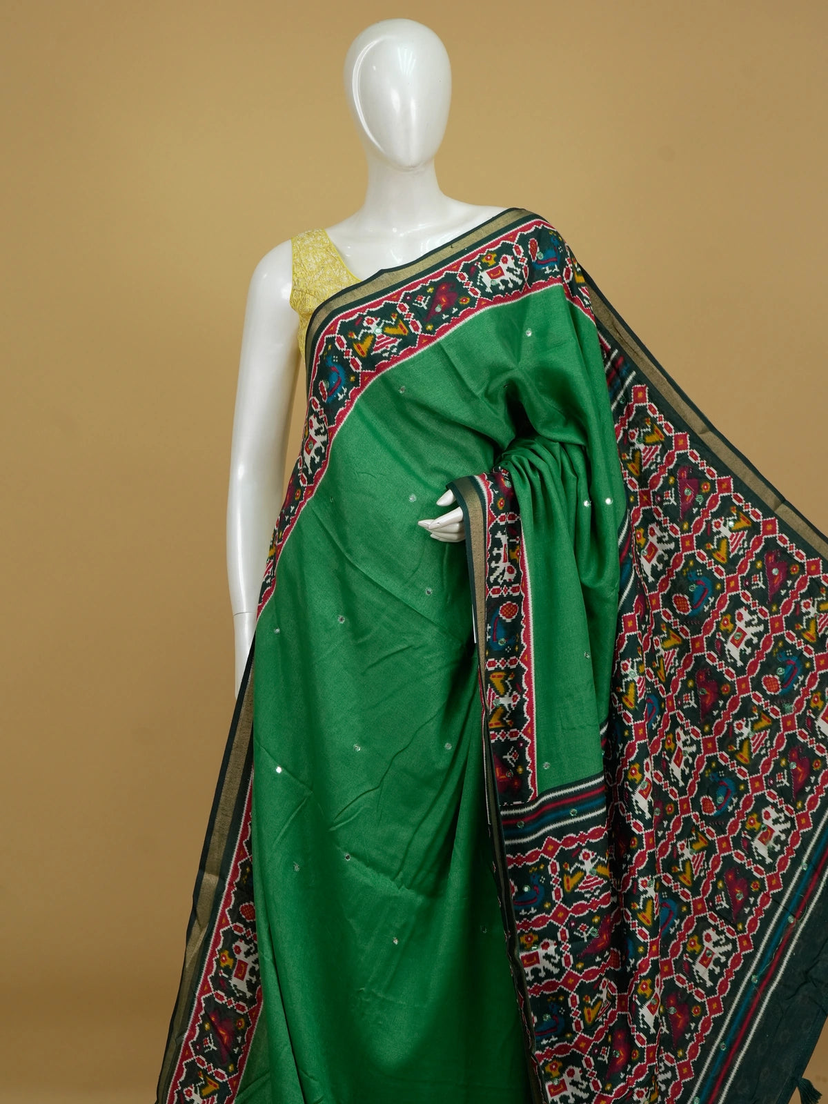 Green linen cotton saree with red patola ikat border, mirror work and multicolour pallu motifs