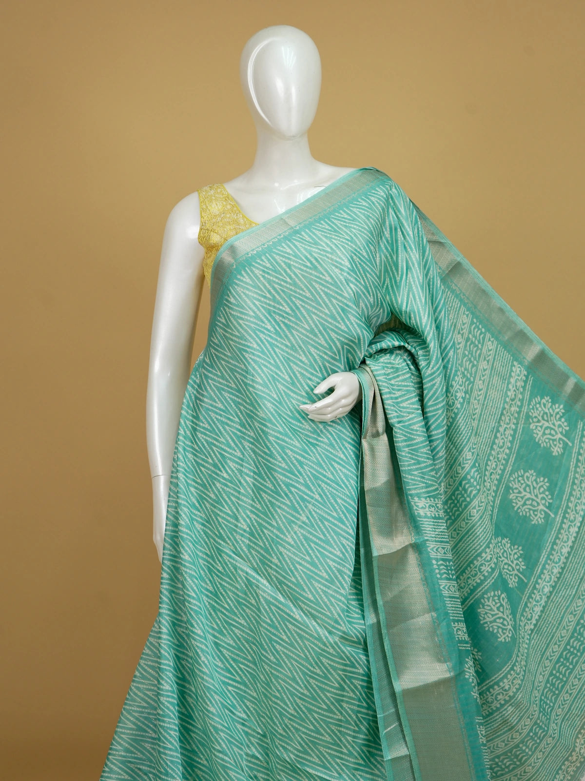 Sea green designer saree with gold zari chevron print, tree-motif pallu and contrast yellow blouse