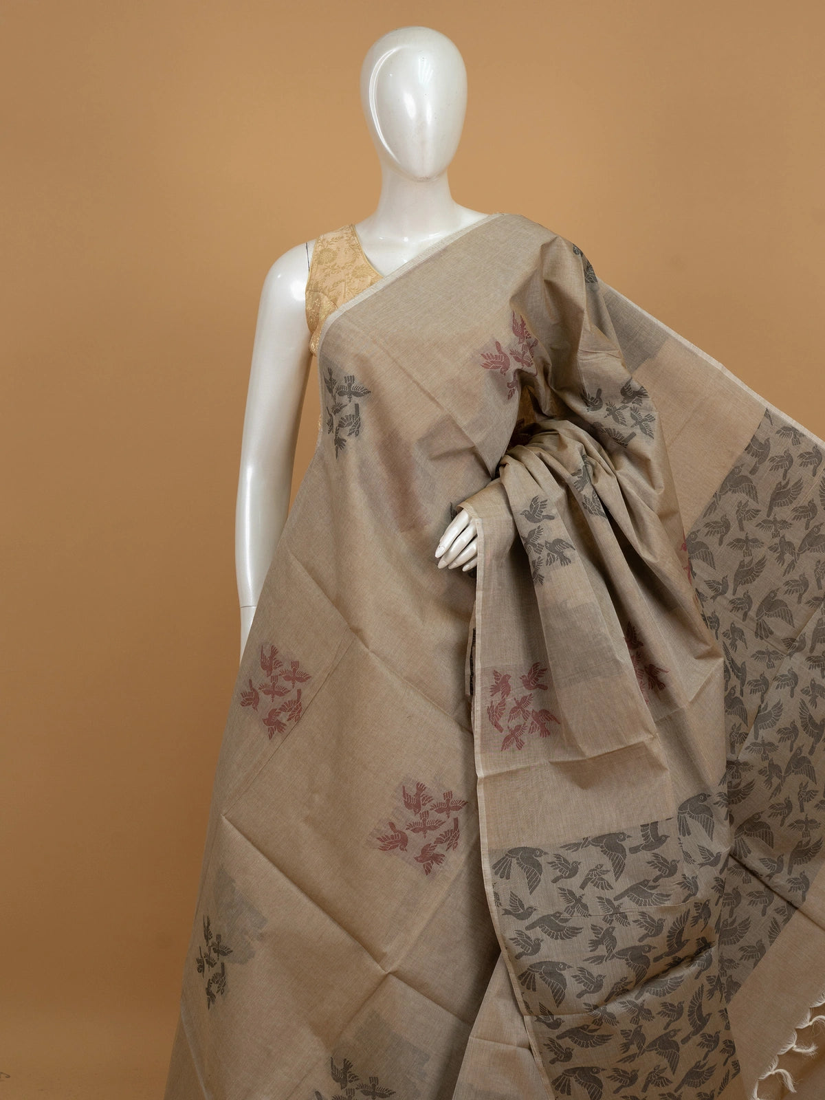 Beige silk cotton saree with grey and maroon flying-bird motifs and a bird-patterned pallu