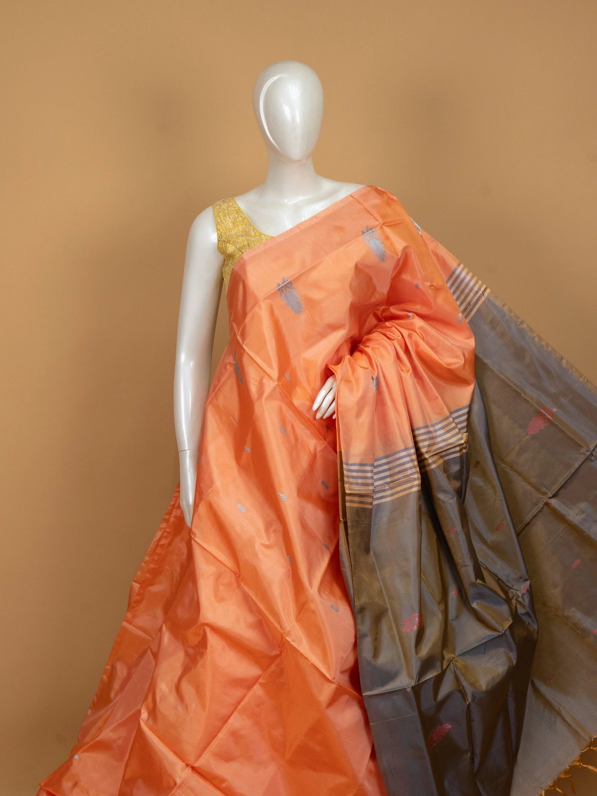 Peach orange banana silk saree with silver buttas and a contrast grey striped pallu