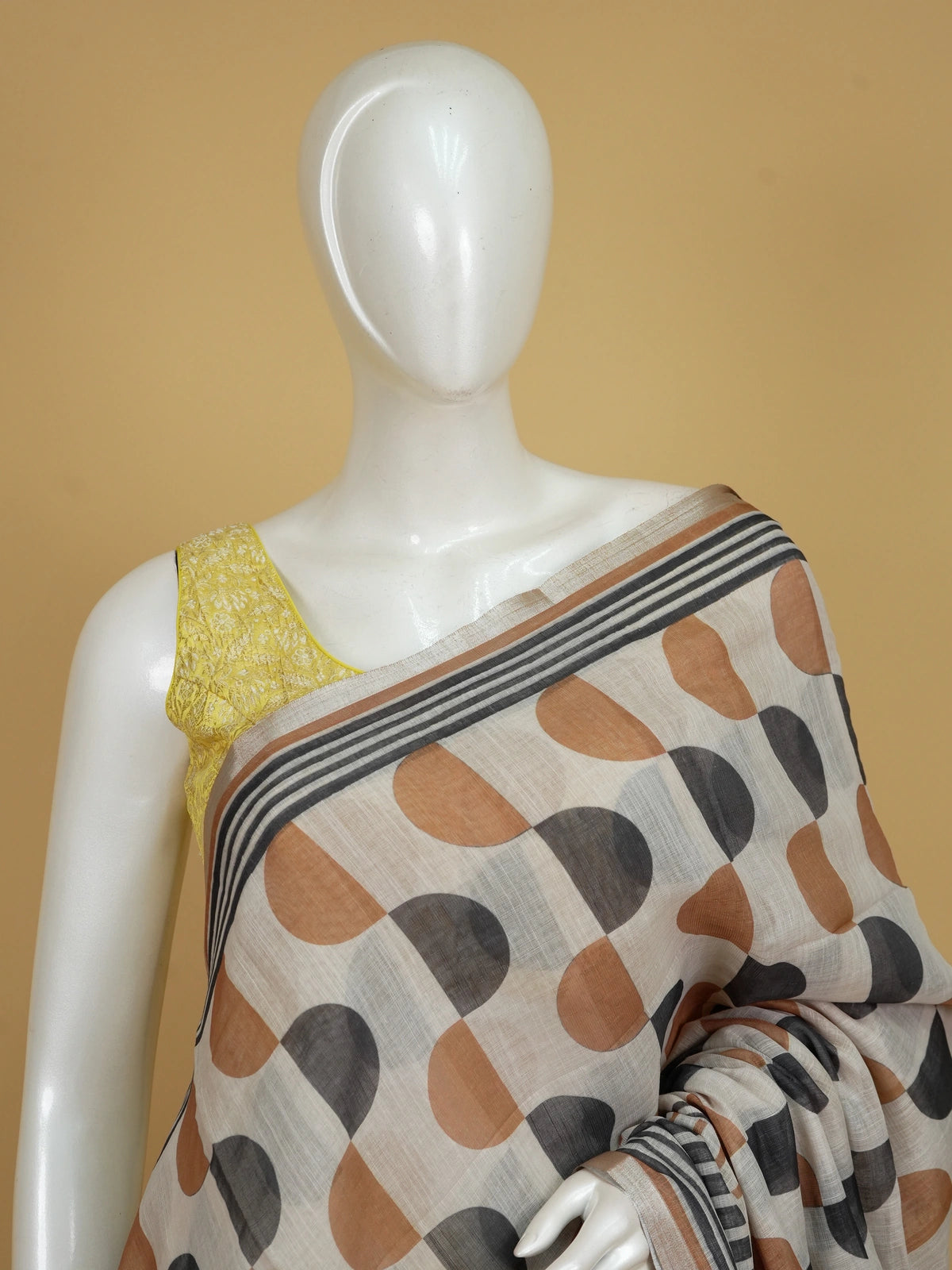 Cream and rust geometric print linen cotton saree with striped border and contrasting blouse