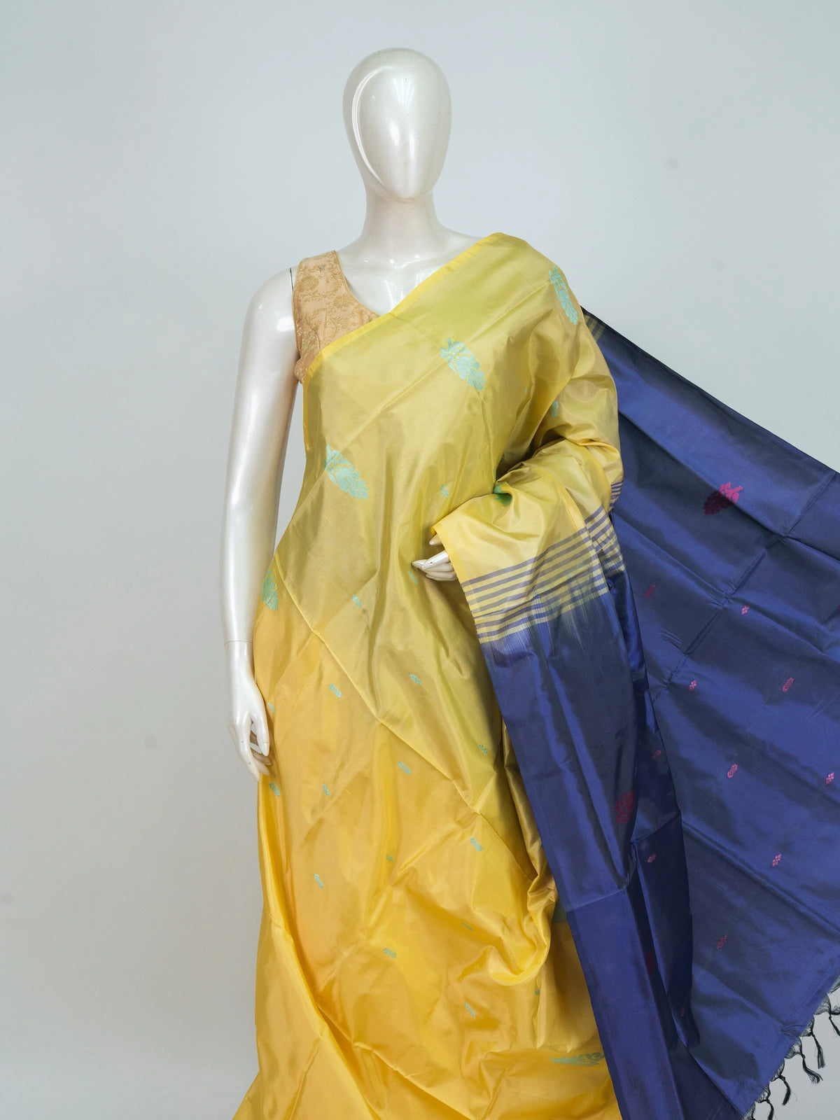 Yellow banana silk saree with navy blue contrast pallu, turquoise buttas and gold zari striped border