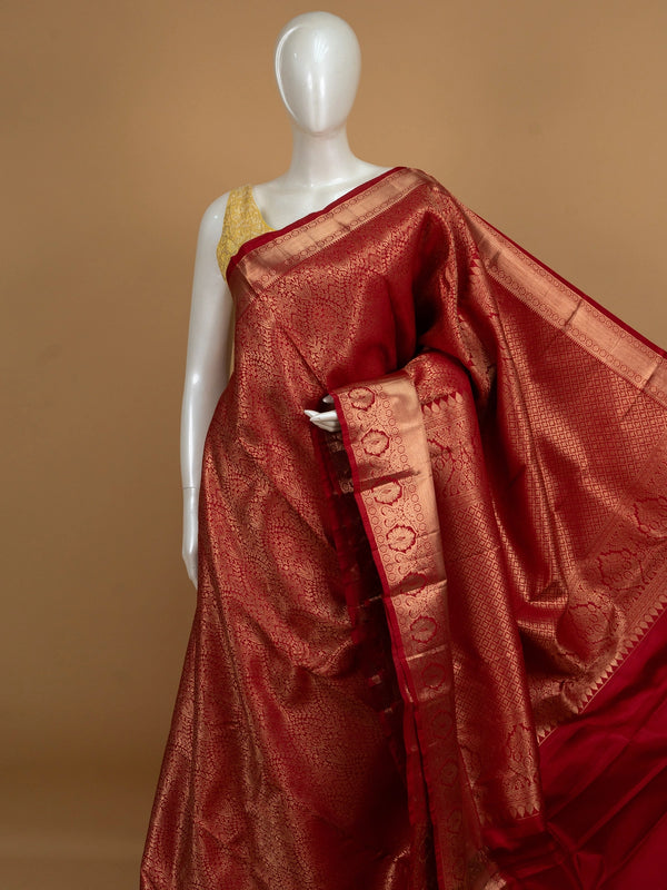Red pure Kanchipuram silk saree with allover gold zari floral brocade and a broad temple-edged zari border