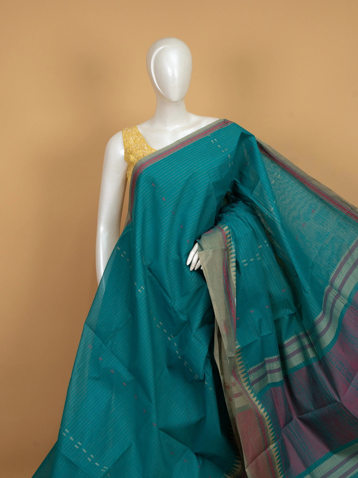 Teal green linen cotton saree with gold zari stripes, pink buti motifs and contrast grey temple border