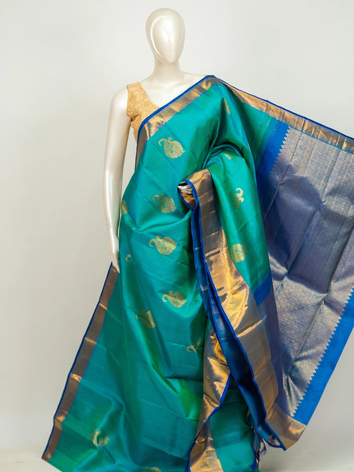 Teal green pure Kanchipuram silk saree with royal blue contrast border and gold zari paisley motifs