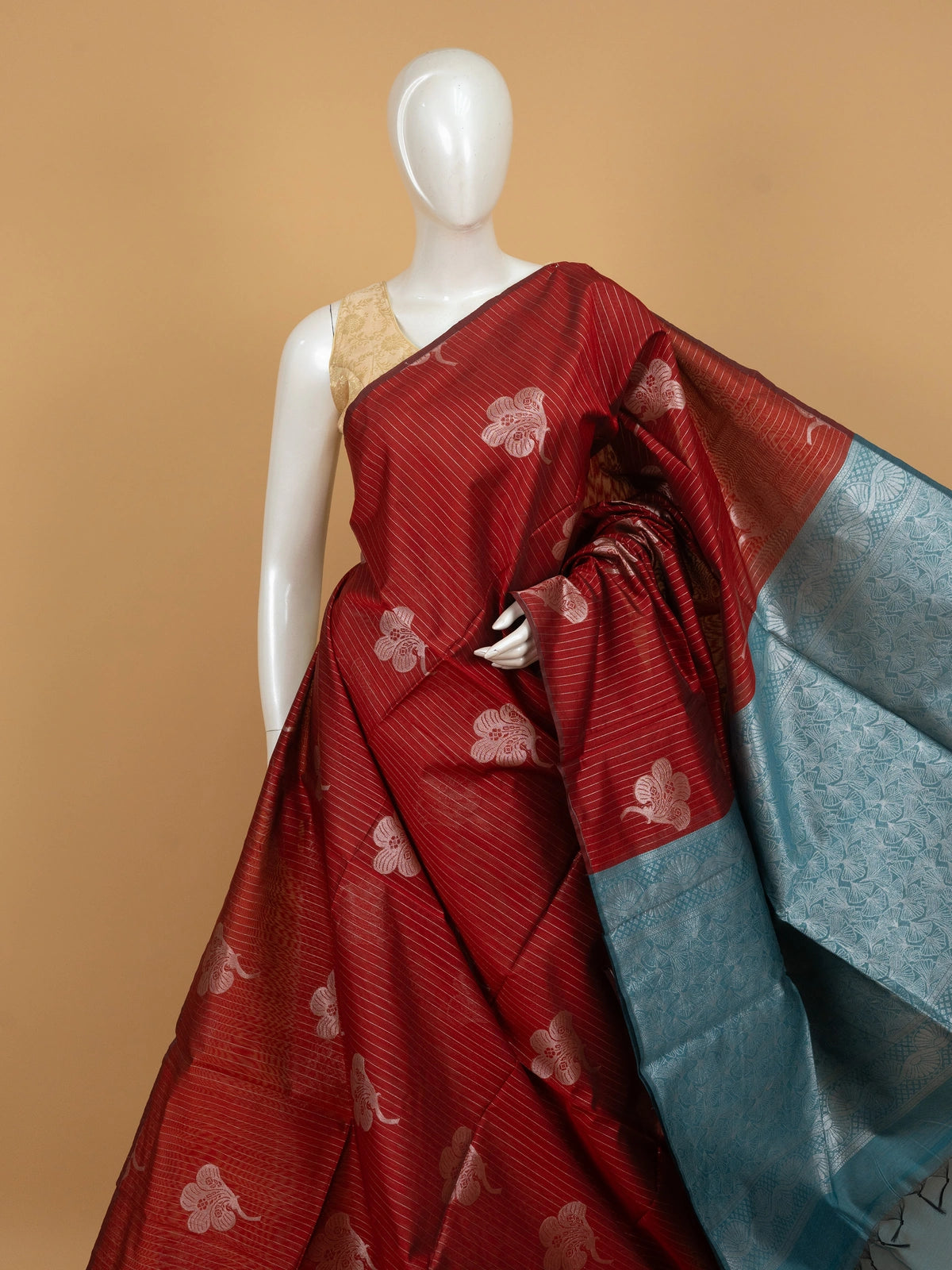 Maroon silk cotton saree with silver zari stripes, floral butta and contrast teal blue zari border
