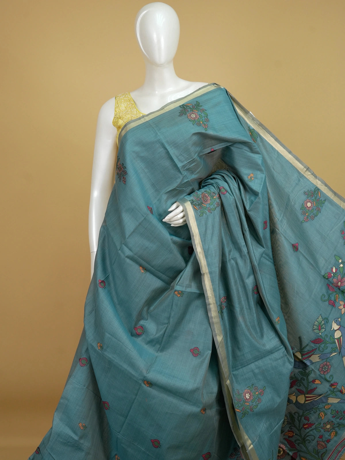 Teal blue linen cotton saree with floral butta body, gold zari border and parrot motif pallu