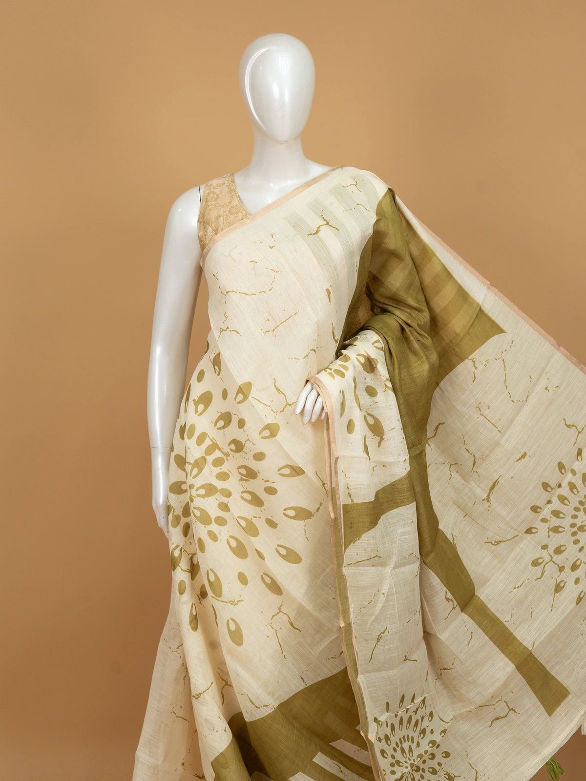 Cream and olive green linen cotton saree with batik-style prints and tree-of-life pallu