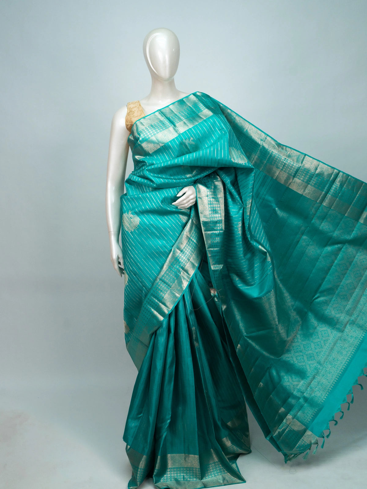Teal green Pure Kanchipuram silk saree with silver zari diagonal stripes, peacock buttas and a woven zari border