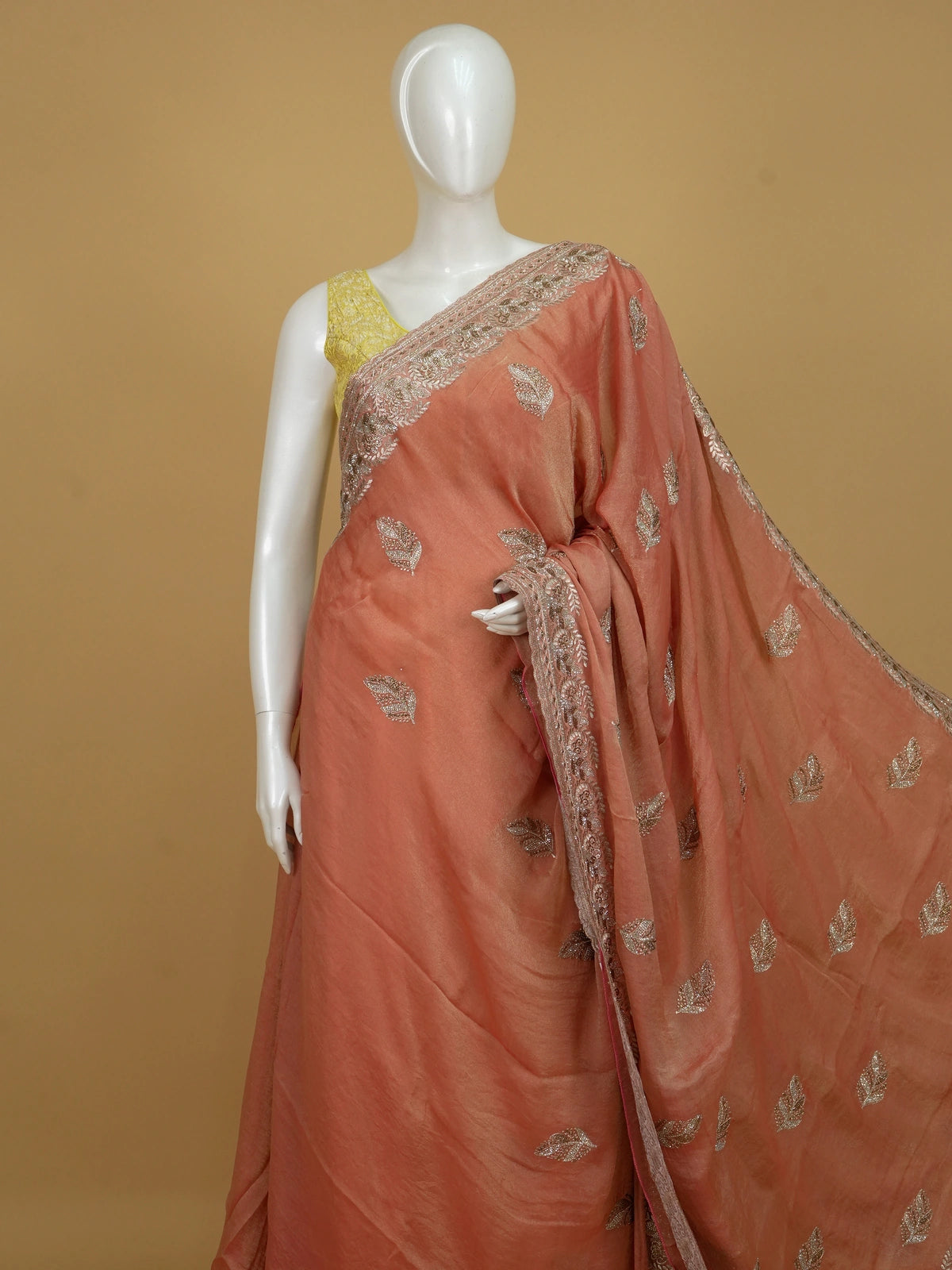 Peach shimmer tissue designer saree with embroidered leaf buttas and an ornate rose-gold border