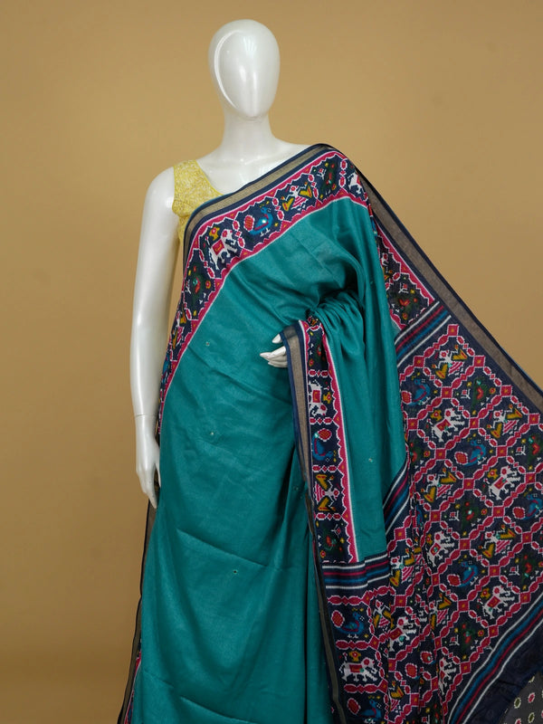 Teal linen cotton saree with navy and pink patola-style border, peacock and elephant motifs, and contrast blouse