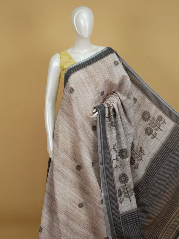 Beige linen cotton saree with grey floral prints and a contrast grey-black striped border