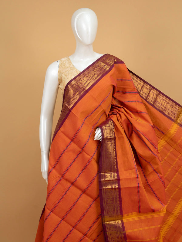 Rust orange Chettinad cotton saree with magenta gold zari border and pink-blue zigzag stripes