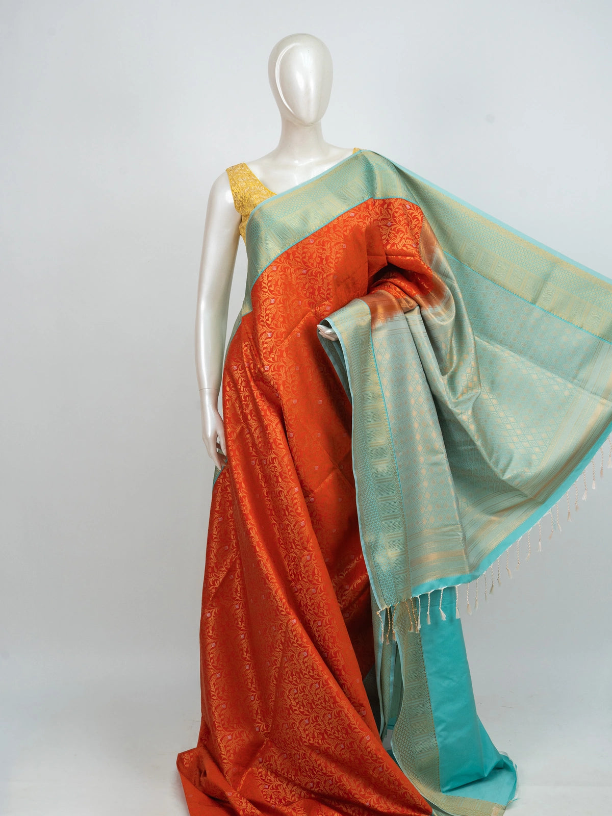 Orange Kanchipuram fancy silk saree with turquoise contrast border, gold zari floral body and diamond-patterned pallu