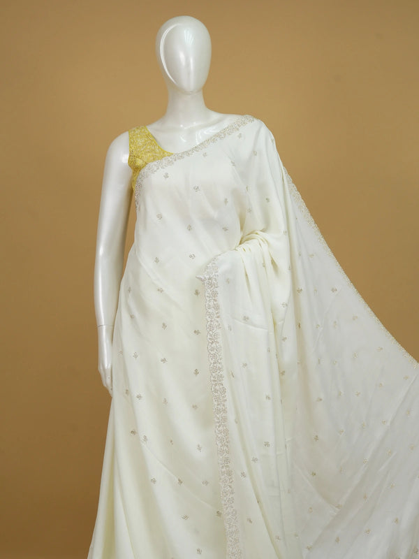 Off-white georgette designer saree with silver floral buttas and scalloped embellished border
