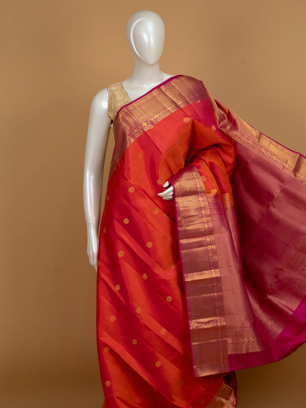 Orange pure Kanchipuram silk saree with contrast pink border and gold zari buttas