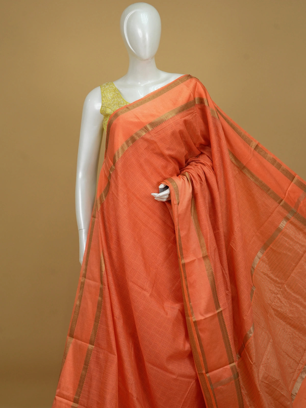 Orange semi tussar saree with gold zari border and geometric patterned body